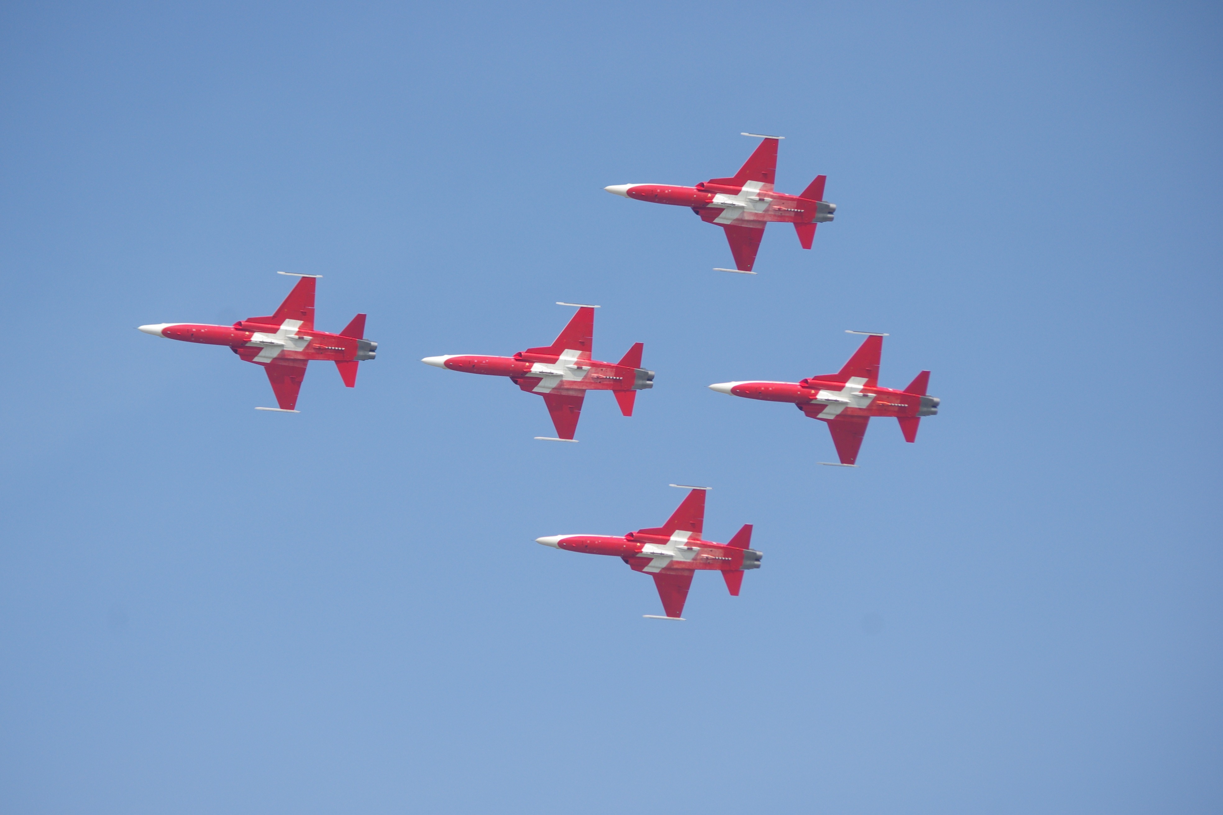 Foto von 5 roten Düsenfliegern mit weissem Schweizer Kreuz auf der Unterseite am 1. August. Der Himmel rundherum ist wolkenlos und ein tiefes Blau.